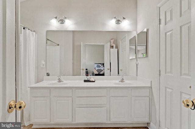bathroom with a sink, ensuite bath, and double vanity