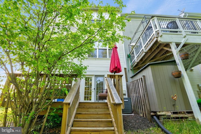rear view of house featuring a deck, central AC, and stairs