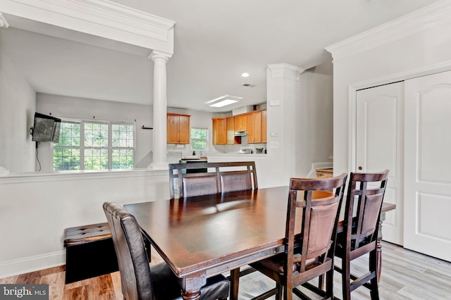 dining space featuring recessed lighting, baseboards, light wood finished floors, and ornate columns