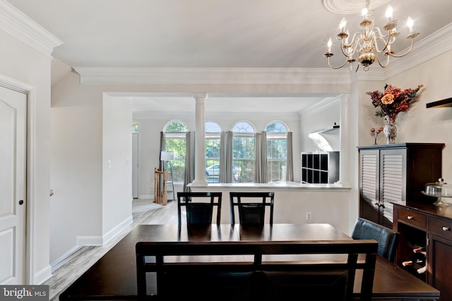 dining space with crown molding, baseboards, wood finished floors, and a notable chandelier