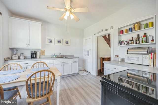 kitchen with white cabinets, electric range, a sink, a ceiling fan, and white microwave