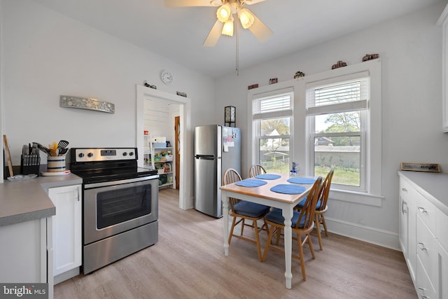 kitchen with light wood-type flooring, a ceiling fan, white cabinetry, and stainless steel appliances