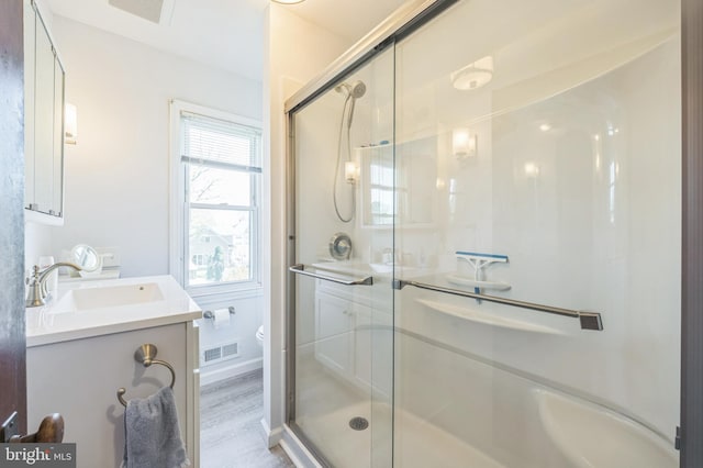 bathroom featuring vanity, a stall shower, toilet, and visible vents