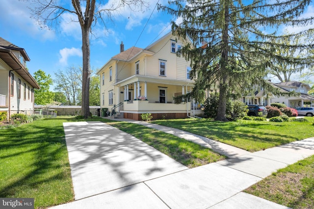 view of home's exterior with covered porch, a yard, and a chimney