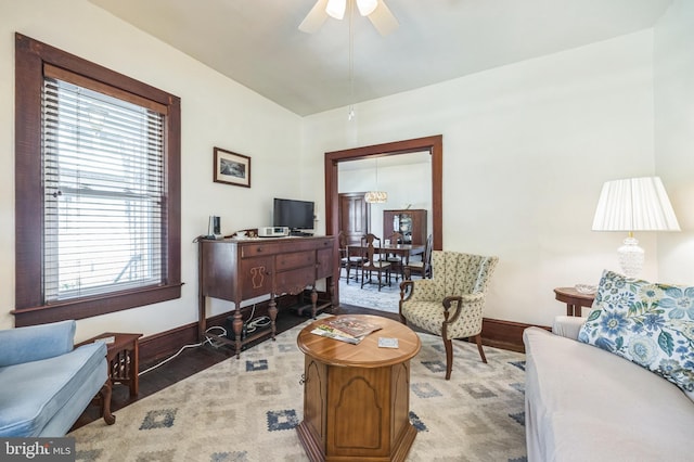living area featuring baseboards, a ceiling fan, wood finished floors, and a healthy amount of sunlight