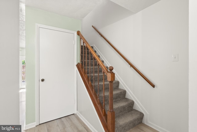 stairway featuring baseboards and wood finished floors