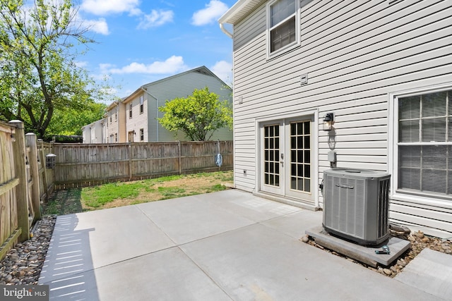 view of patio / terrace with central air condition unit, a fenced backyard, and french doors