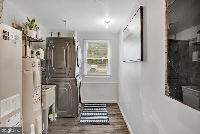 6608 Eaglewing Ln, Fort Washington, MD 20744 - clothes washing area with stacked washer / drying machine, water heater, wood finished floors, and baseboards