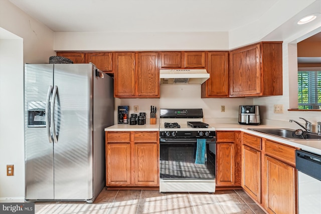 10048 Quiet Brook Ln, Clinton, MD 20735 - kitchen with under cabinet range hood, a sink, dishwashing machine, gas range, and stainless steel refrigerator with ice dispenser