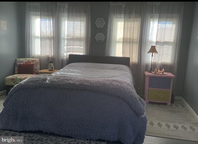 bedroom featuring baseboards, multiple windows, and carpet flooring