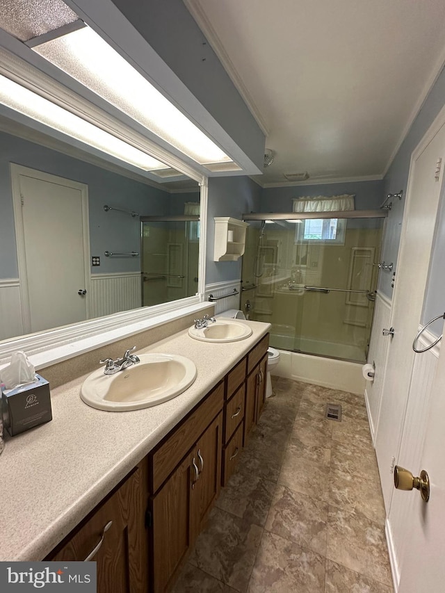 full bathroom featuring an enclosed shower, toilet, a sink, and double vanity