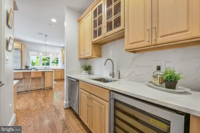 kitchen featuring light brown cabinets, a sink, light wood-style floors, and wine cooler