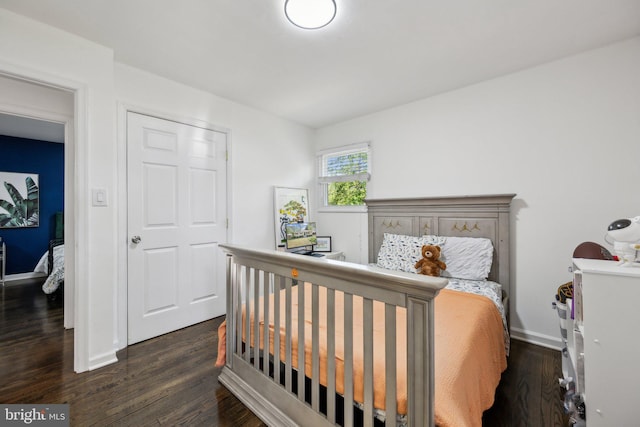 bedroom with baseboards and dark wood-style flooring