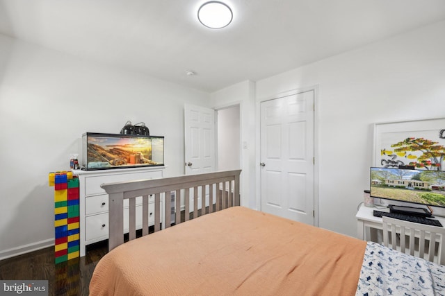 bedroom with baseboards and wood finished floors