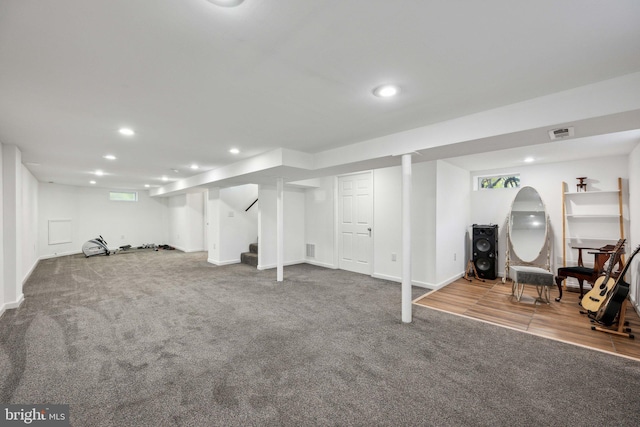 finished below grade area with visible vents, recessed lighting, stairs, and carpet flooring