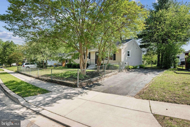 obstructed view of property featuring a gate, a fenced front yard, driveway, and a front yard