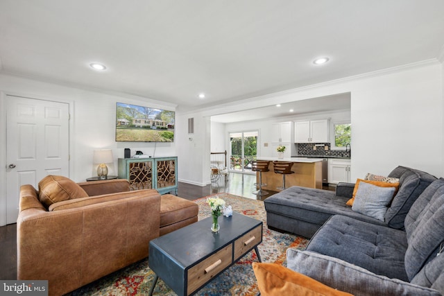 living room featuring crown molding, recessed lighting, and dark wood-type flooring