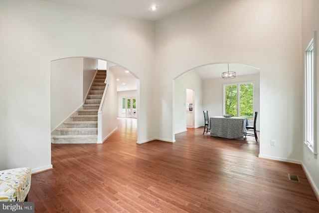 1145 Water Pointe Ln, Reston, VA 20194 - unfurnished living room featuring wood finished floors, healthy amount of natural light, a high ceiling, baseboards, and recessed lighting