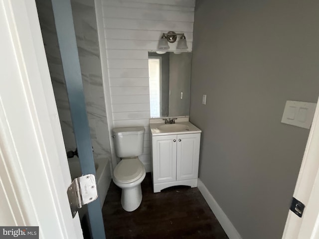 full bathroom featuring vanity, baseboards, wood finished floors, and toilet