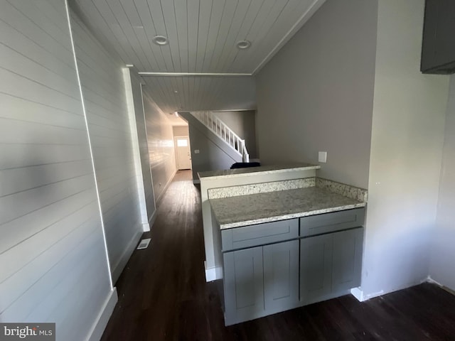 hallway featuring wooden ceiling, dark wood-style floors, and stairs