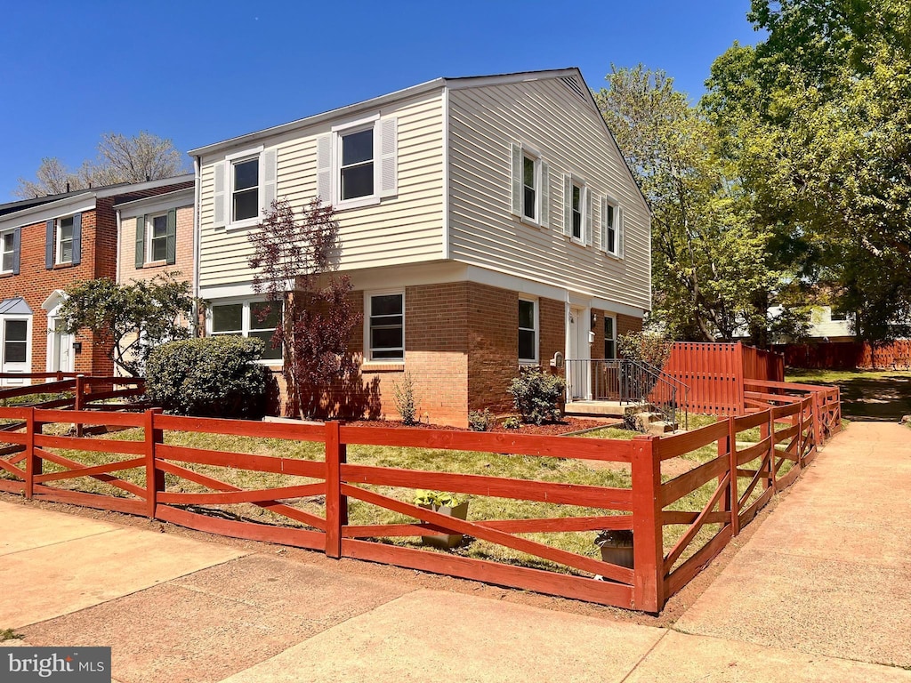 view of front of property with a fenced front yard and brick siding
