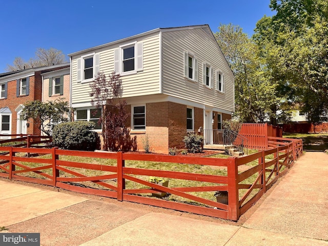 view of front of property with a fenced front yard and brick siding