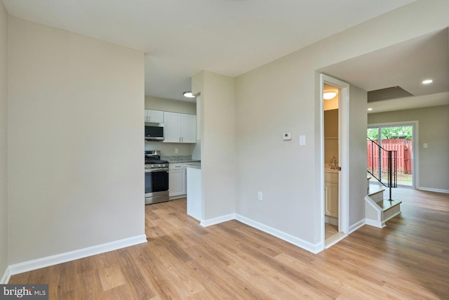 8321 Irongate Way, Manassas, VA 20109 - kitchen with stainless steel appliances, light wood-style floors, white cabinetry, baseboards, and light countertops
