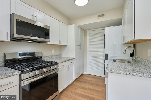 8321 Irongate Way, Manassas, VA 20109 - kitchen featuring stainless steel appliances, a sink, white cabinetry, light wood-style flooring, and light stone counters