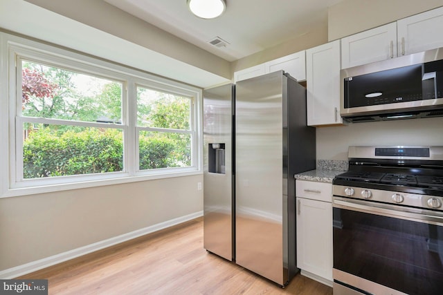 8321 Irongate Way, Manassas, VA 20109 - kitchen with stainless steel appliances, plenty of natural light, white cabinetry, and light wood-type flooring