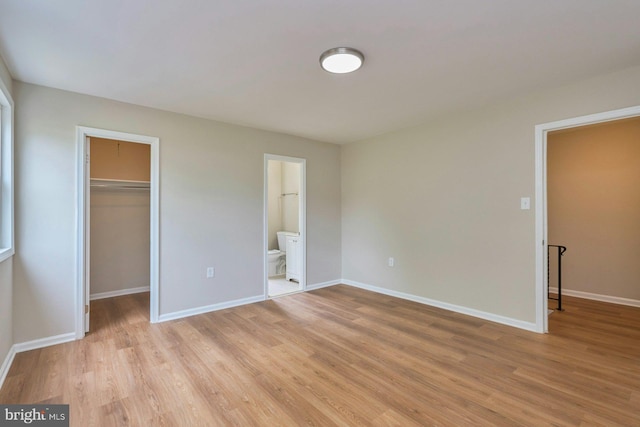8321 Irongate Way, Manassas, VA 20109 - unfurnished bedroom with a spacious closet, light wood-type flooring, and baseboards