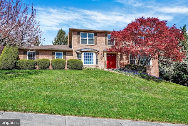 traditional-style house with a front yard and brick siding