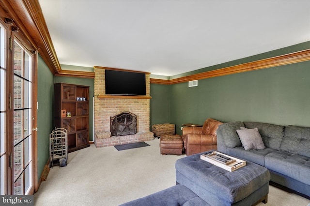living room with visible vents, carpet flooring, a brick fireplace, and crown molding