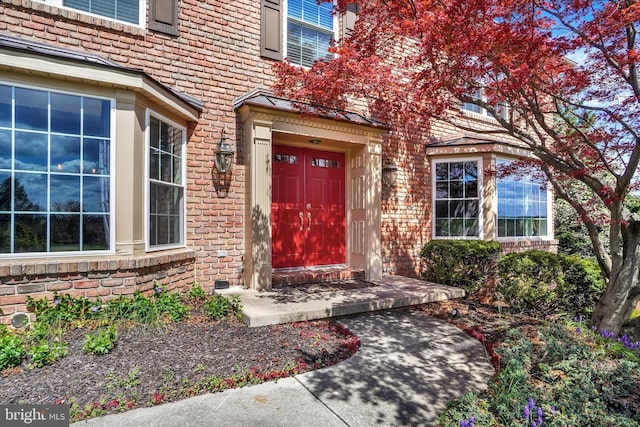 view of exterior entry featuring brick siding