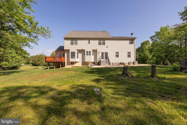 rear view of house featuring entry steps, a patio area, a lawn, and a deck