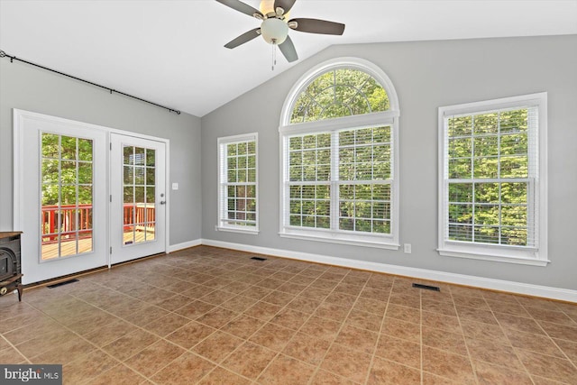 unfurnished sunroom with french doors, vaulted ceiling, and a wood stove