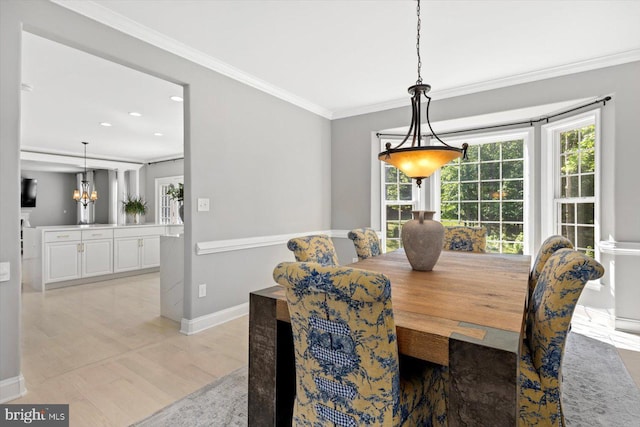 dining room featuring plenty of natural light, ornamental molding, baseboards, a chandelier, and light wood-style flooring