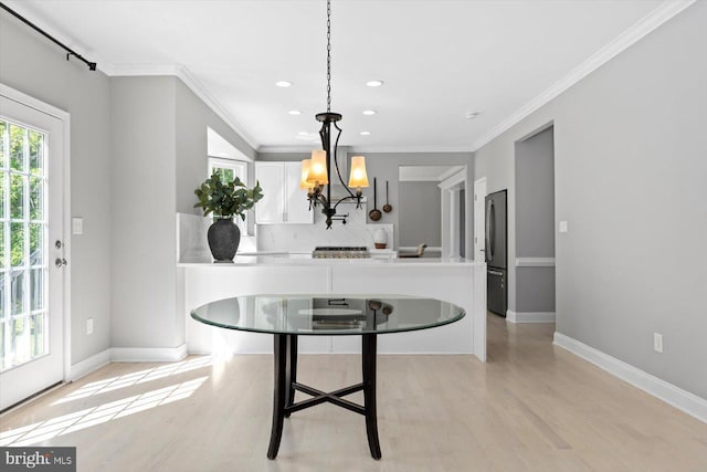 dining area featuring light wood-style floors, recessed lighting, ornamental molding, a chandelier, and baseboards