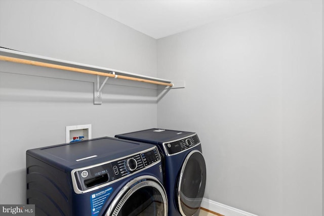 laundry room featuring washer and dryer and baseboards
