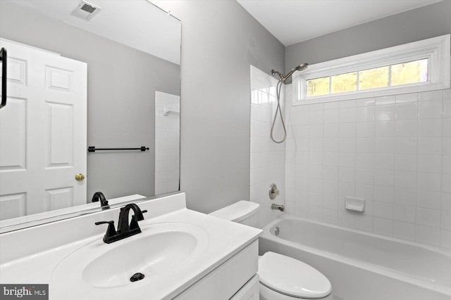 bathroom featuring toilet, vanity, and shower / tub combination