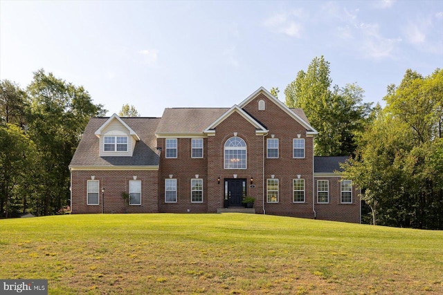 colonial home featuring a front lawn and brick siding