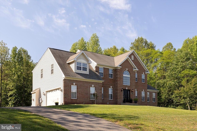 view of front of property with an attached garage, asphalt driveway, brick siding, and a front yard