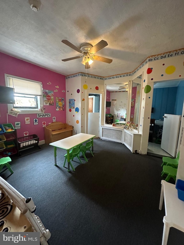 bedroom featuring carpet floors, a textured ceiling, and ceiling fan