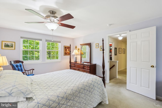 bedroom with light carpet and a ceiling fan