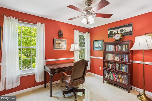 carpeted home office featuring a ceiling fan and baseboards