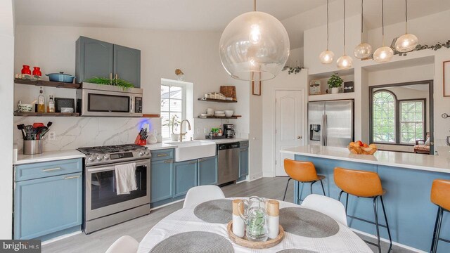 11400 Rolling Green Pl, Hagerstown, MD 21742 - kitchen with stainless steel appliances, a breakfast bar, open shelves, blue cabinetry, and light wood-style floors
