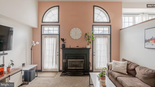 11400 Rolling Green Pl, Hagerstown, MD 21742 - living room featuring a fireplace with flush hearth, light carpet, and a towering ceiling