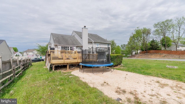 11400 Rolling Green Pl, Hagerstown, MD 21742 - back of house with fence, a trampoline, a yard, a wooden deck, and a chimney