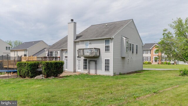 11400 Rolling Green Pl, Hagerstown, MD 21742 - back of property with a trampoline, a balcony, a yard, a chimney, and a shingled roof