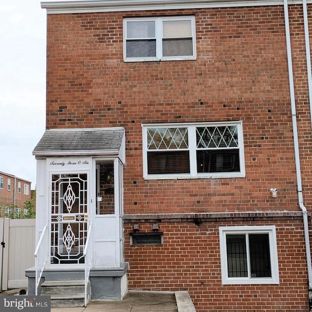 view of front of property with brick siding and fence