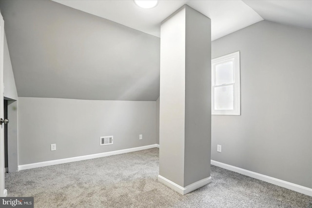 additional living space with baseboards, carpet, vaulted ceiling, and visible vents
